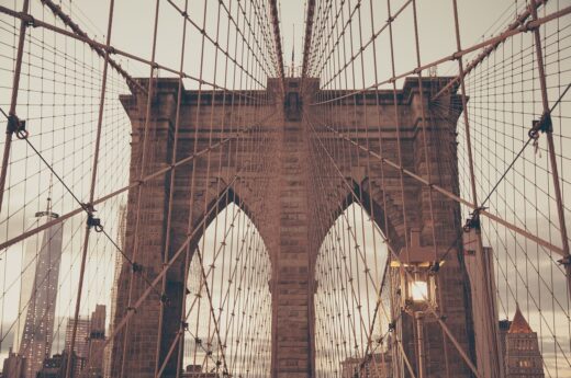 A photo of the Brooklyn Bridge's archways, with suspension cables crisscrossing the visual field.